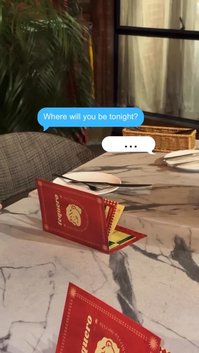 Tequero Tacos dining area — red menu cards on marble table, tropical plant, soft evening light